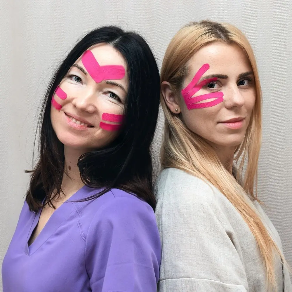 Due donne lato a lato con applicazione di kinesiotaping sul viso.